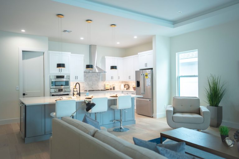 open concept kitchen gray island white shaker cabinets