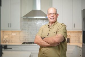 smiling man in white shaker cabinets kitchen