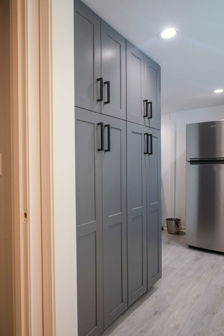 stacked washer dryer next to dark gray shaker cabinets